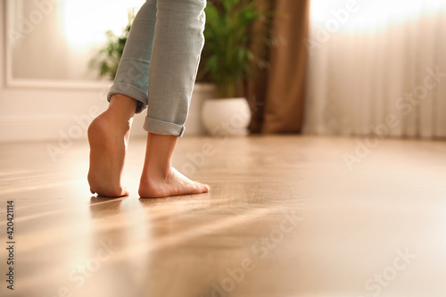 Barefoot woman at home, closeup. Floor heating system