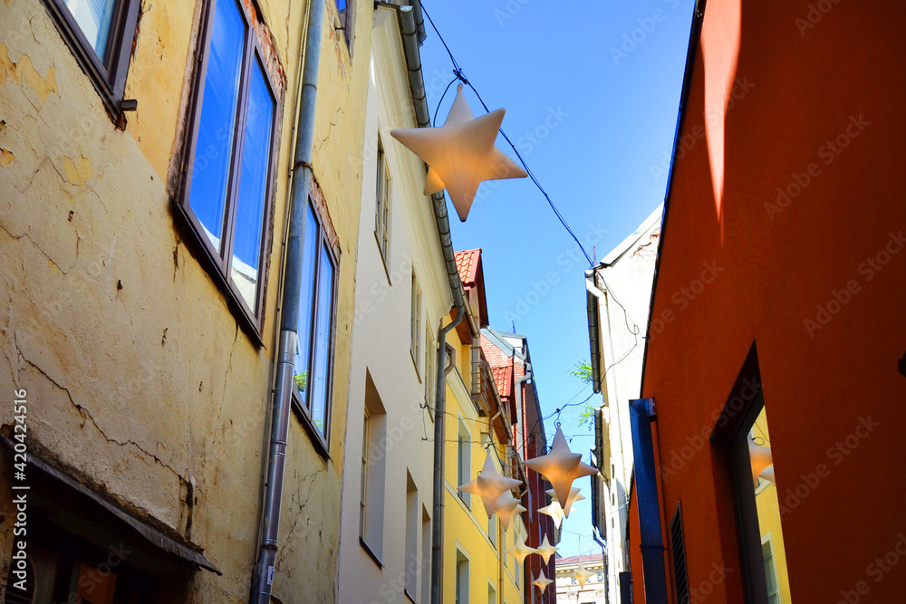 Narrow pedestrian street with star shaped lanterns hanging above. Old Town of Riga, Latvia,  Baltic States