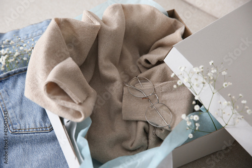 Soft cashmere sweater in box on sofa, closeup