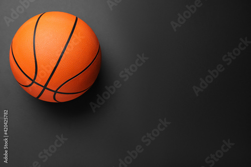 Orange ball on black background, top view with space for text. Basketball equipment