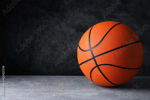 Orange ball on light grey table, space for text. Basketball equipment © New Africa
