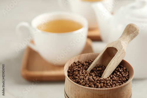 Canvastavla Bowl with buckwheat tea granules and wooden scoop on table, closeup