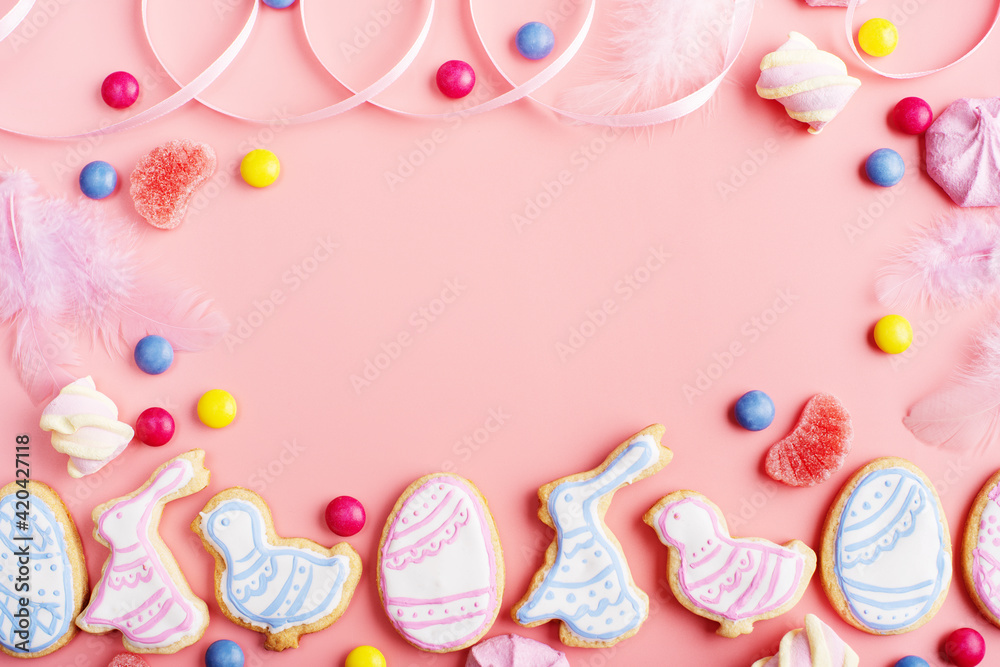 Candies and Easter frosted cookies in shape of egg chicken and rabbit on pink background. Flat lay mockup with copy space. Candies and Easter frosted cookies in shape of egg chicken and rabbit on pink background. Flat lay mockup with copy space.