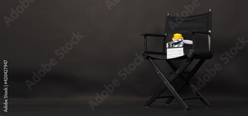 BLACK director chair with Clapperboard or movie Clapper board and megaphone on black background.it use in video production or film and cinema industry.