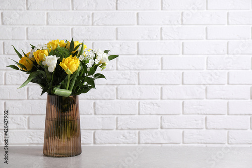 Beautiful bouquet with peony tulips on grey table near white brick wall. Space for text