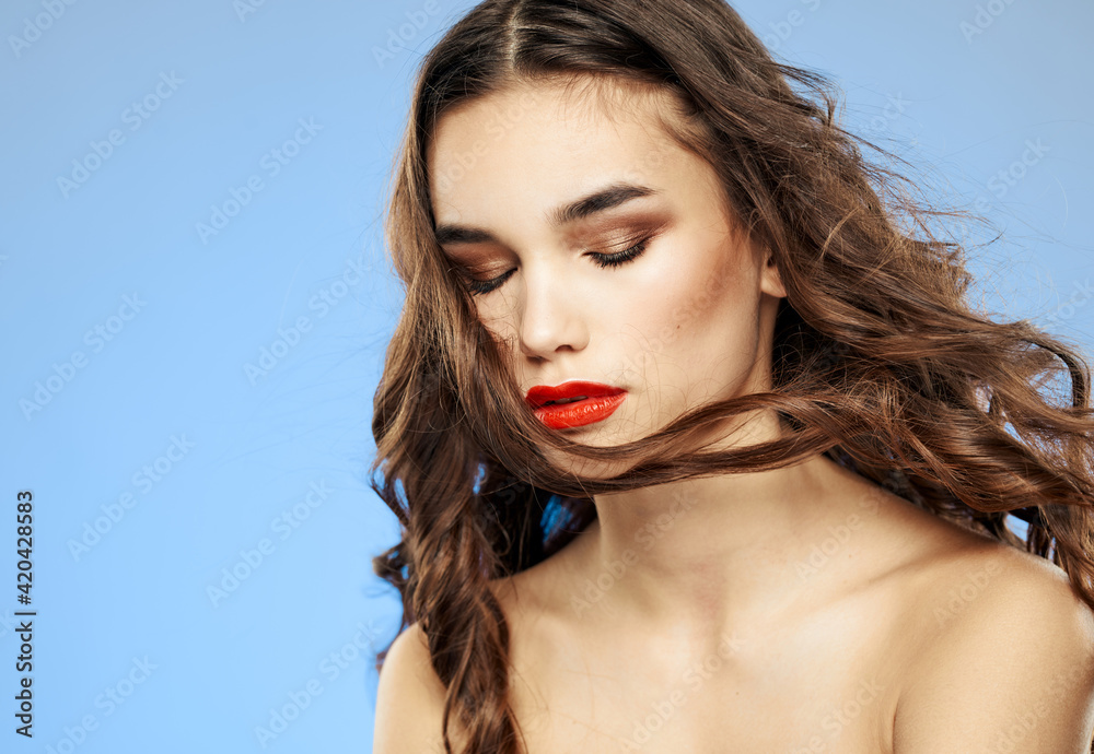 Woman on a dim background with long hair and red lips model makeup