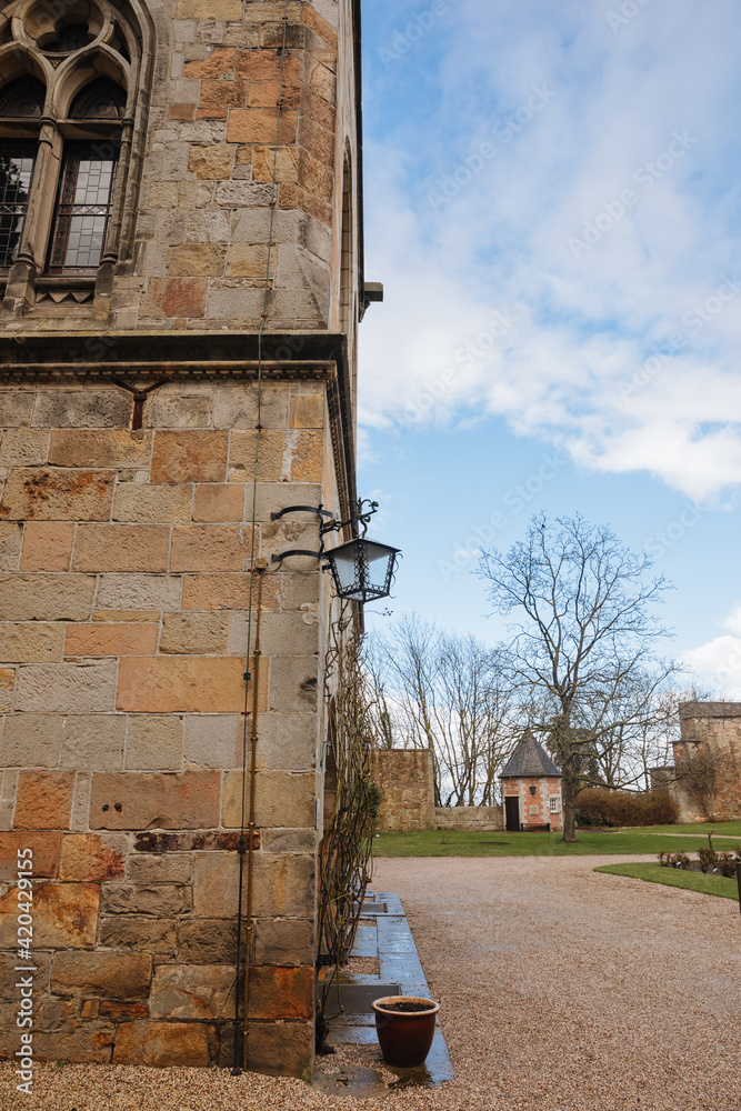 Fototapeta premium Black iron lamp on an old building in Germany. Wall lantern on an old castle