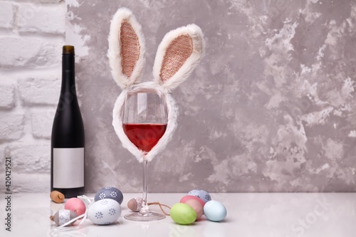 Sticker Glass of wine with Easter decorations, colorful eggs on table