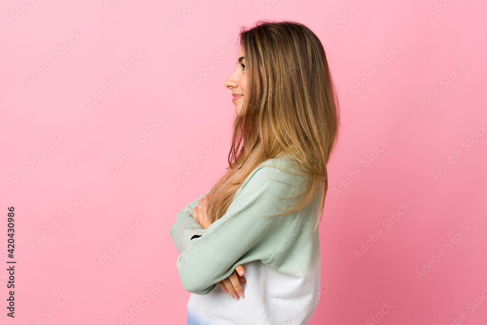 Young woman over isolated pink background in lateral position Young woman over isolated pink background in lateral position