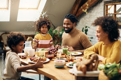Happy black family enjoying in meal at dining table at home. photo