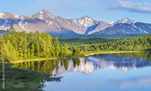 Wild forest lake in the Altai mountains on a summer morning, picturesque reflection