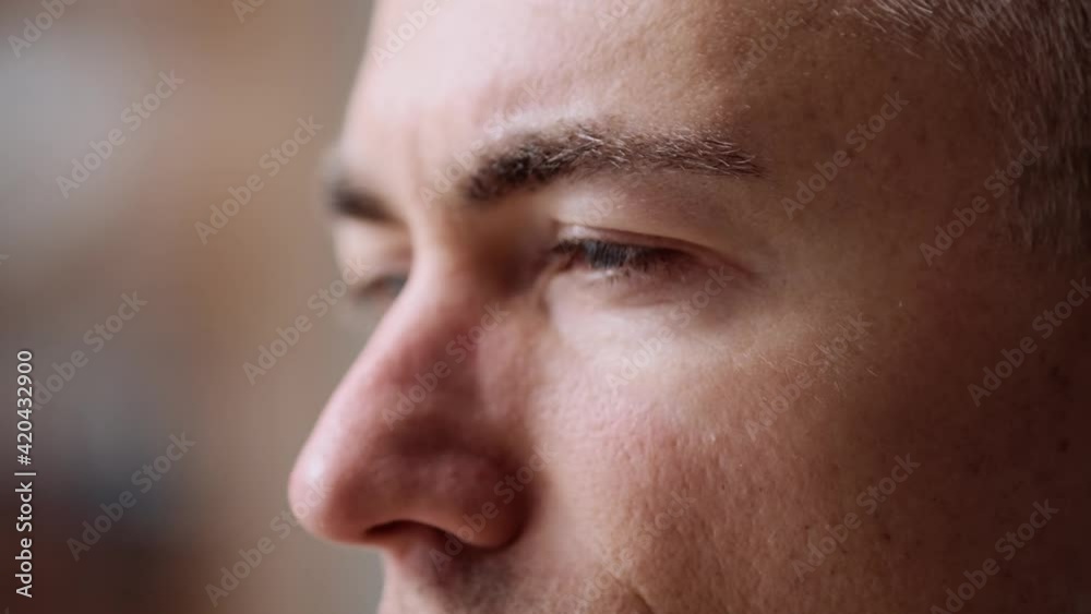 A close-up side view of a serious businessman is working with his computer sitting in the office A close-up side view of a serious businessman is working with his computer sitting in the office