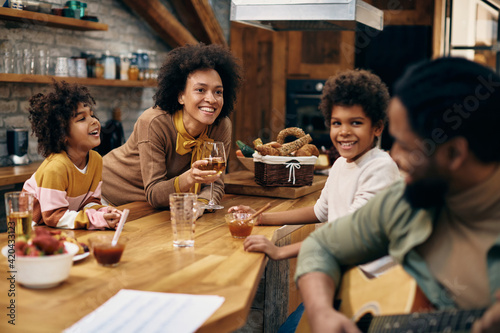 Happy African American family enjoying in acoustic music at home.