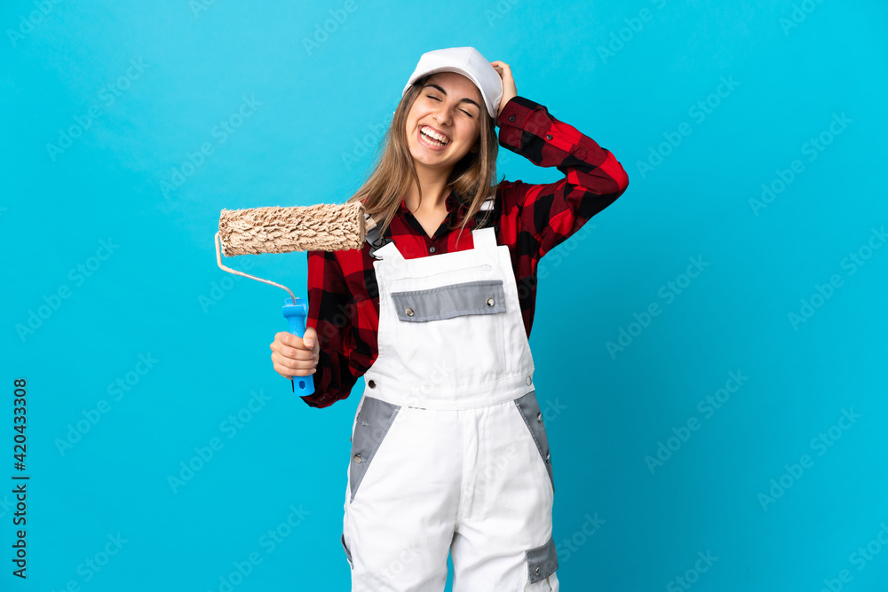 Painter woman over isolated blue background laughing Painter woman over isolated blue background laughing