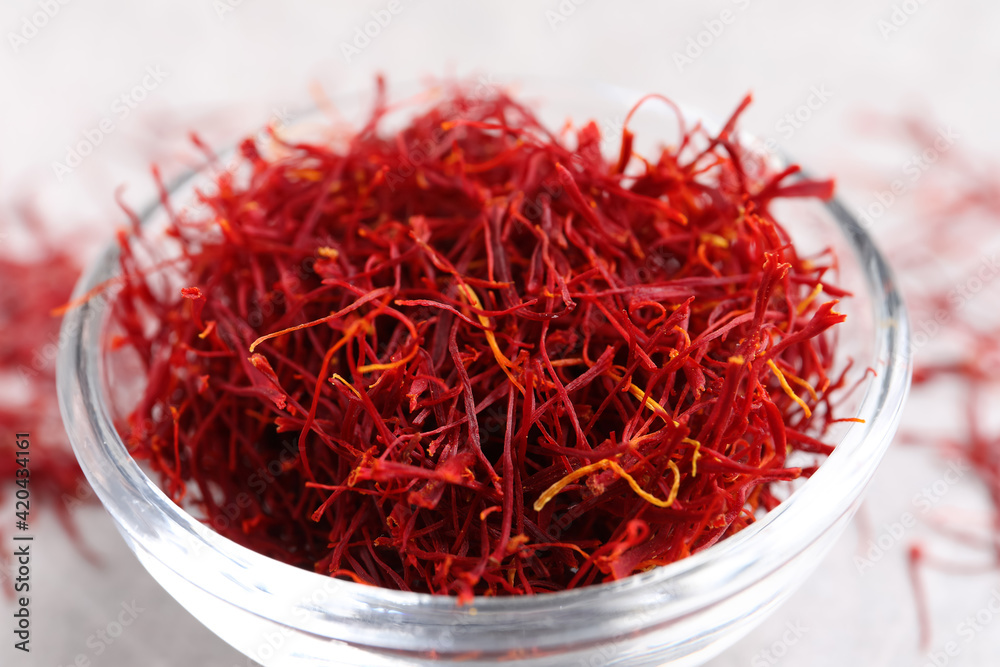 Fototapeta premium Dried saffron in glass bowl on table, closeup