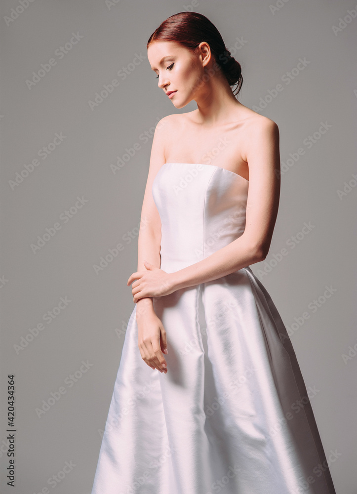 White glossy wedding dress. Studio portrait of beautiful young bride. Classic wedding style. Marriage day. White glossy wedding dress. Studio portrait of beautiful young bride. Classic wedding style. Marriage day.