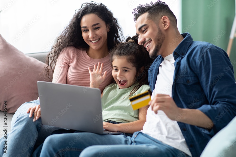 Arabic Family Of Three With Laptop And Credit Card Making Online Shopping Arabic Family Of Three With Laptop And Credit Card Making Online Shopping