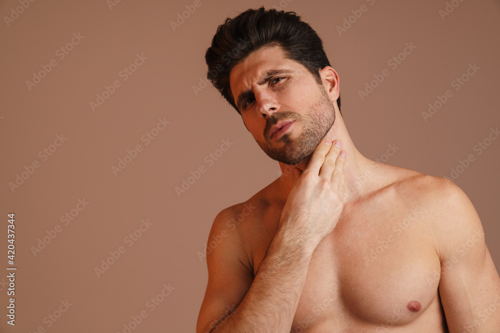 Fototapeta premium Brooding half-naked man looking at camera and rubbing his neck