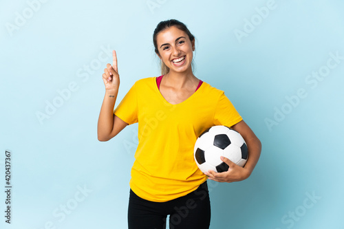 Young hispanic football player woman over isolated on blue background showing and lifting a finger in sign of the best © luismolinero
