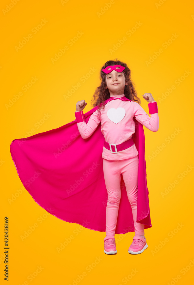 Strong little superhero kid girl showing muscles Strong little superhero kid girl showing muscles