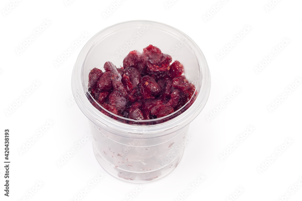 Dried cranberries in closed plastic food container on white background Dried cranberries in closed plastic food container on white background