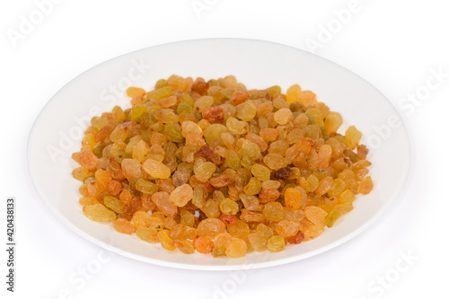 Golden yellow raisins on dish on white background, selective focus