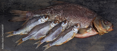 Salted and dried bream and several roach on black surface photo