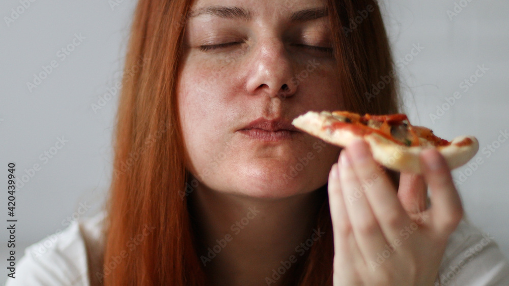 Young chubby woman with long hair holding tasty big slice of pizza ready to eat at home Young chubby woman with long hair holding tasty big slice of pizza ready to eat at home