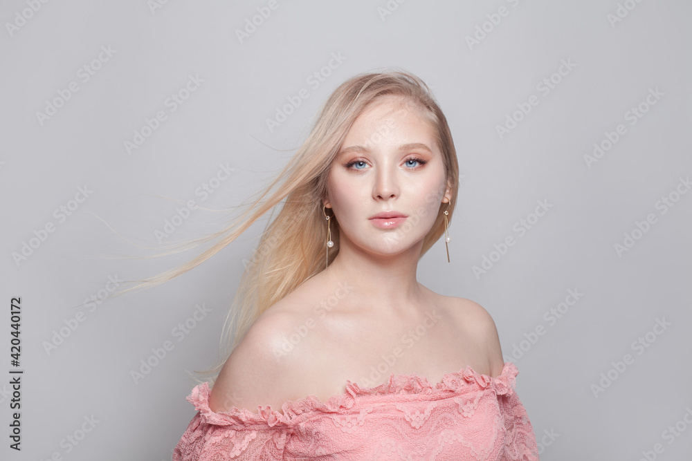 Gentle young woman with blonde hair and pearls earrings on white background Gentle young woman with blonde hair and pearls earrings on white background