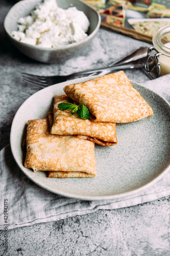 crepes with homemade cottage cheese on a gray plate