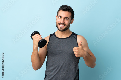 Young sport man with beard making weightlifting with thumbs up because something good has happened