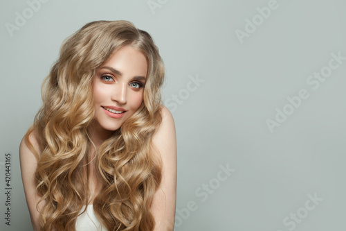 Young blonde woman smiling on white background