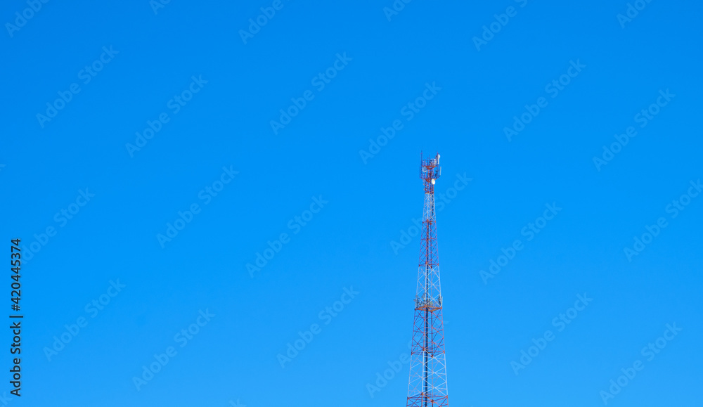 Telecommunications tower with blue sky equipment on telecommunications tower. Communication technologies. Telecommunications industry. Mobile or telecommunication network Telecommunications tower with blue sky equipment on telecommunications tower. Communication technologies. Telecommunications industry. Mobile or telecommunication network