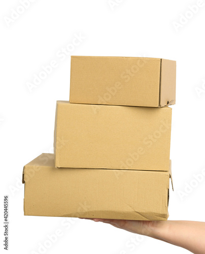 hand holds a brown cardboard box of paper on a white isolated background