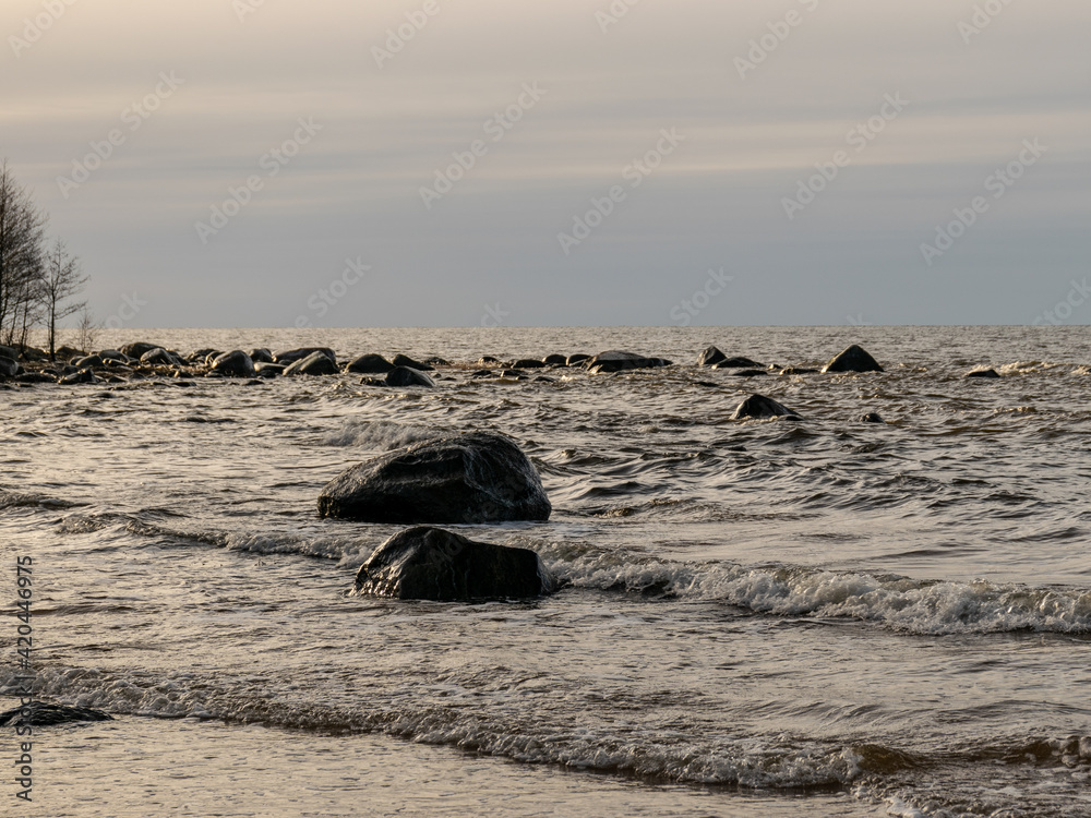 landscape with stony beach and lonely man silhouette in the evening