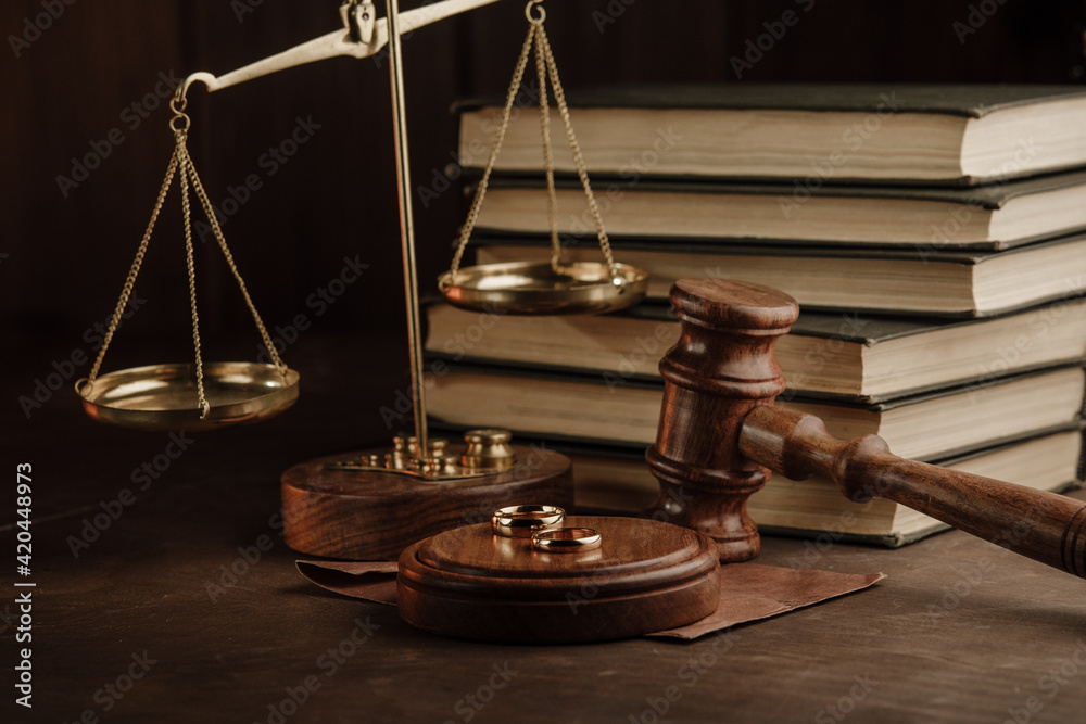 Divorce and separation concept. Judge gavel and golden rings in notary public office Divorce and separation concept. Judge gavel and golden rings in notary public office