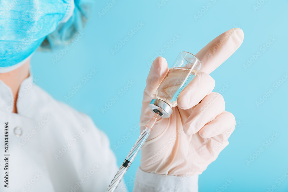 Doctor making vaccination in protective mask and gloves. Covid 19 Vaccine in glass vial bottle and syringe, medicine liquid in doctor hand for injection. Vaccination and immunization. Doctor making vaccination in protective mask and gloves. Covid 19 Vaccine in glass vial bottle and syringe, medicine liquid in doctor hand for injection. Vaccination and immunization.