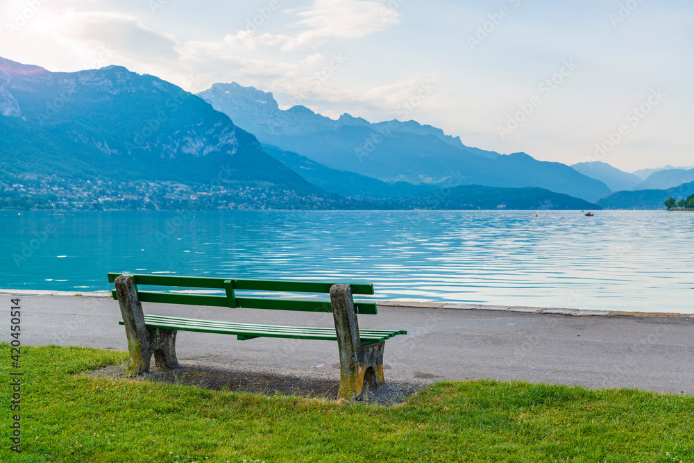 Park bench on the lake with a beautiful mountain view.
