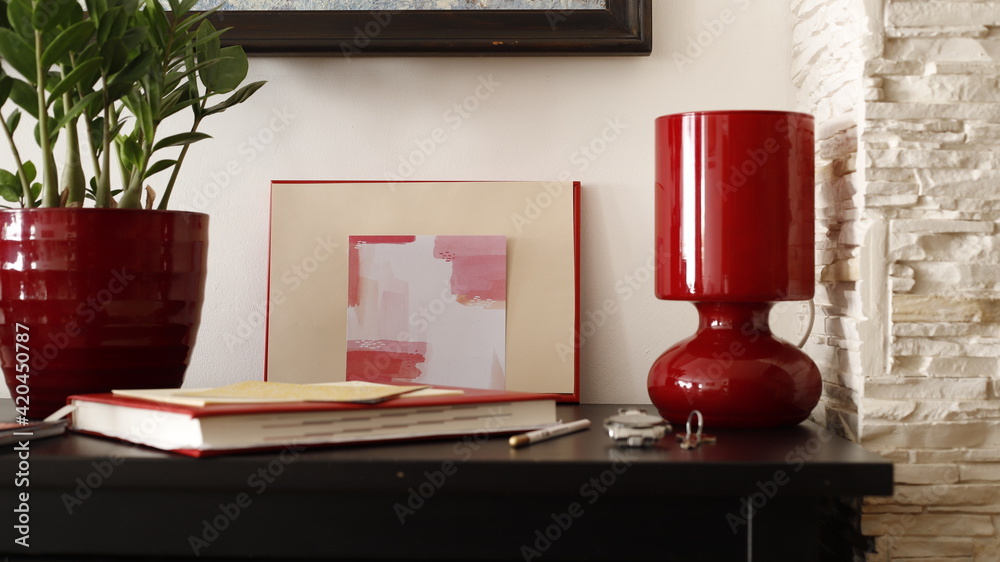 Komódka mebel w salonie z ramką czerwoną, karteczką kolorową i lampką szklaną bordową - obrazy, fototapety, plakaty 