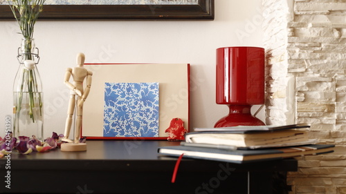 Komódka mebel w salonie z ramką czerwoną, karteczką kolorową i lampką szklaną bordową © Seance_Photo_Sylwia