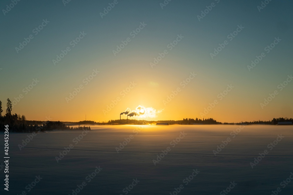 Sunrise over factory in Finland in winter