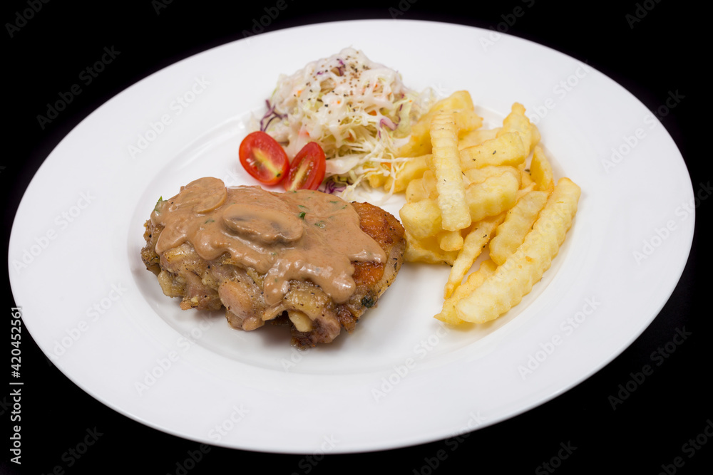 Steak with mushroom sauce, french fries and salad on plate. Steak with mushroom sauce, french fries and salad on plate.