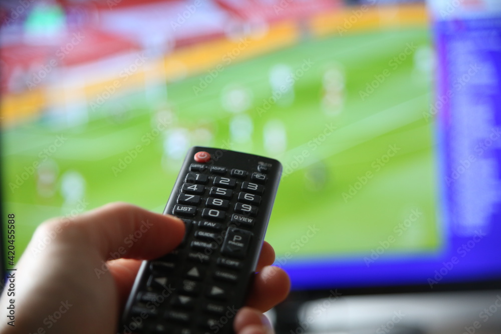 Fußball im TV schauen. Mann mit Fernbedienung im Vodergrund. Fußball im TV schauen. Mann mit Fernbedienung im Vodergrund.