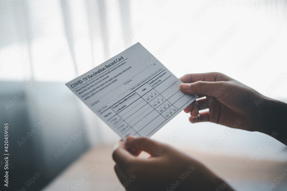 Obraz premium Coronavirus vaccination record card is held in hand. patient who has already been vaccinated with Coronavirus .Coronavirus prevention 