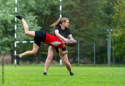 Girls playing rugby together outside in summer. Woman sport concept