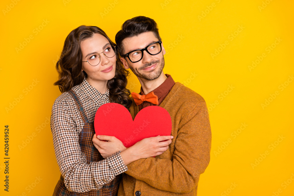 Portrait of nice dreamy affectionate couple friends friendship embracing heart shape looking aside isolated on bright yellow color background Portrait of nice dreamy affectionate couple friends friendship embracing heart shape looking aside isolated on bright yellow color background