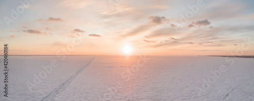 Ice on the frozen sea and bright colored sky at sunset