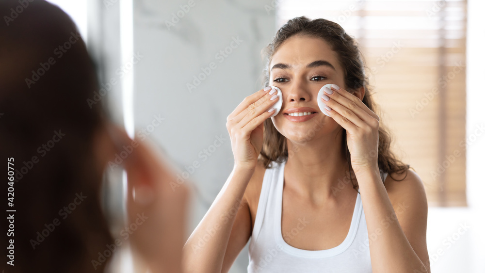 Woman Moisturizing Skin Removing Makeup With Cotton Pads In Bathroom Woman Moisturizing Skin Removing Makeup With Cotton Pads In Bathroom