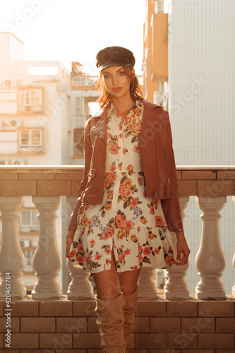 beautiful woman in visor cap and light dress walking towards camera