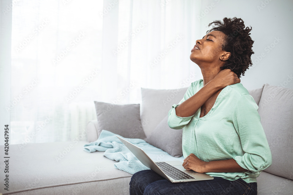 African young woman have neck ache during working with laptop at home. Young Businesswoman Suffering From Neckache. Woman having neck pain while working on computer laptop African young woman have neck ache during working with laptop at home. Young Businesswoman Suffering From Neckache. Woman having neck pain while working on computer laptop